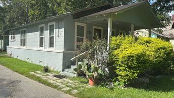 A single-story house with a porch, a small front yard, and a mailbox.