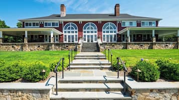 A large, two-story house with a stone facade, a front porch, and a well-maintained lawn.