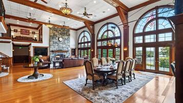 A spacious interior with a dining area, a fireplace, and large windows offering views.