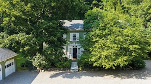 A two-story house with a front porch, surrounded by dense trees. - Preston House by Avantstay Book-lined Library + Sunroom + Dining for 8 Near Hiking Trails + Metro-north (Dover Plains)