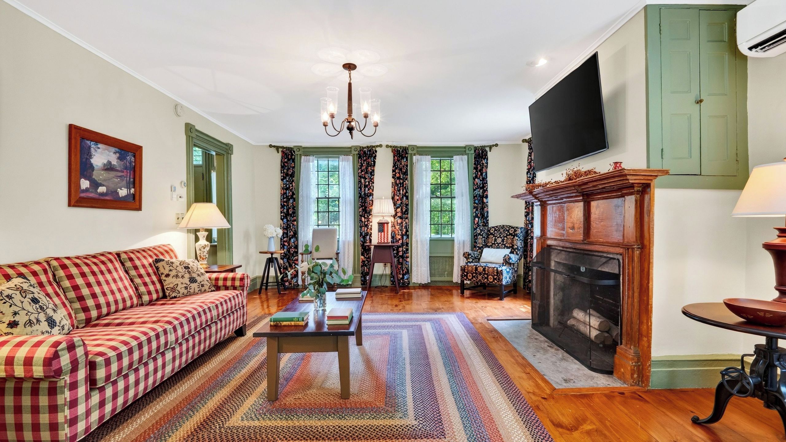 A living room with a sofa, a coffee table, a fireplace, and a television.