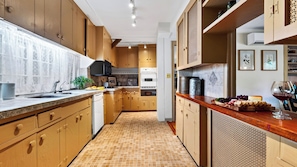 A kitchen with wooden cabinets, a tiled backsplash, and a countertop with food items. - Preston House by Avantstay Book-lined Library + Sunroom + Dining for 8 Near Hiking Trails + Metro-north (Dover Plains)