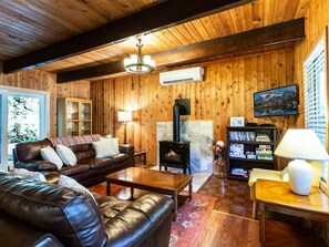 A cozy living room with a fireplace, leather sofa, and a television.