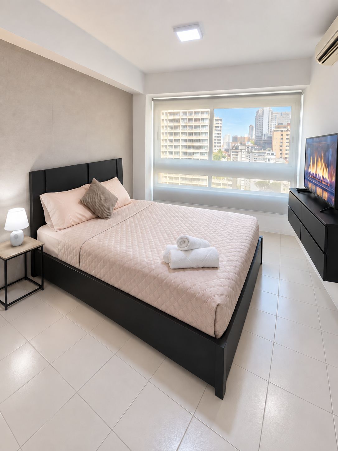 Une chambre d’hôtel moderne avec un grand lit, une télévision et une vue sur la ville.