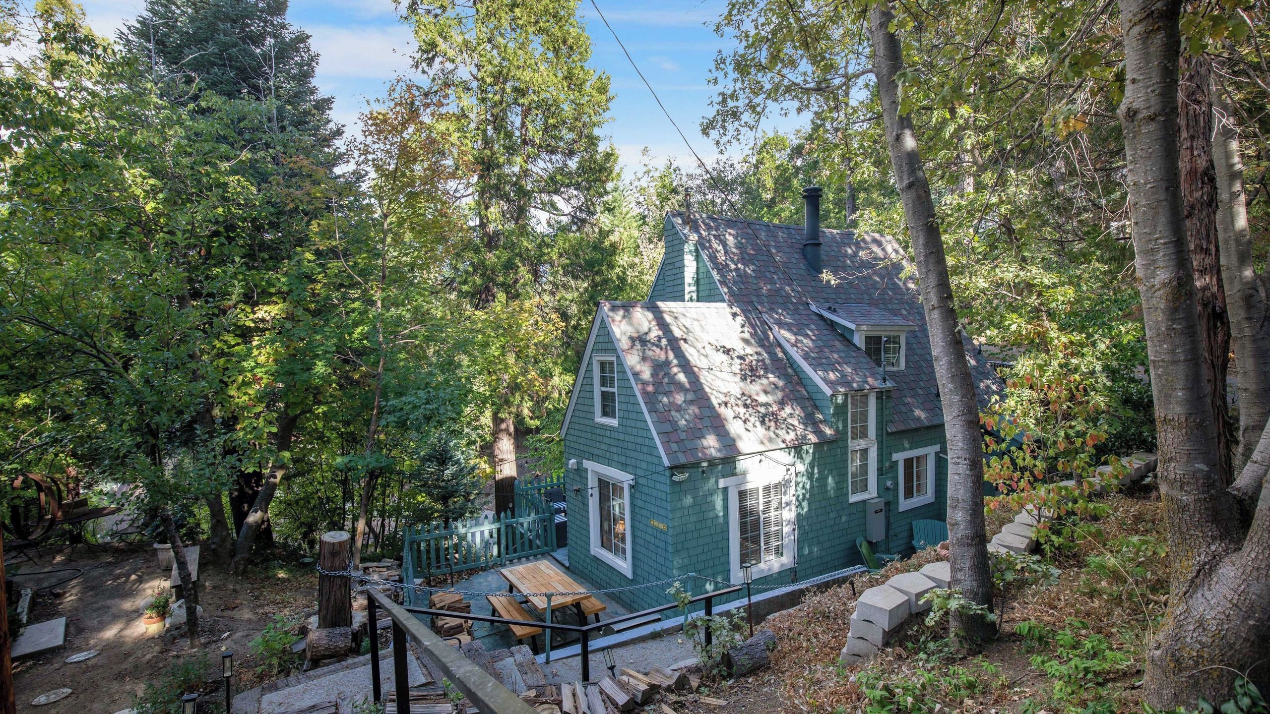 A house surrounded by trees with a covered patio area.