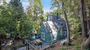 Ein Haus, umgeben von Bäumen, mit einer überdachten Terrasse.