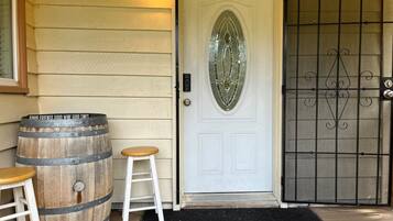 A white door with a glass panel, a metal gate, and two wooden barrels.