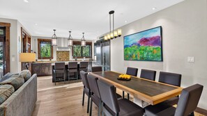 Eine moderne Küche mit Essbereich, Holzboden und einem Gemälde an der Wand.