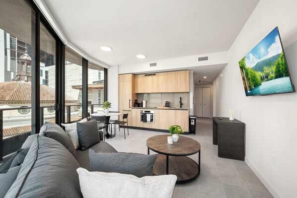 Een moderne woonkamer met een bank, een ronde salontafel en een eethoek.
