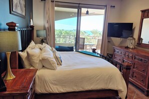 A hotel room with a bed, a television, a dresser, and a view of the outdoors. - Elevated Bella Sirena Views: 2nd Floor Luxury (Puerto Peñasco)