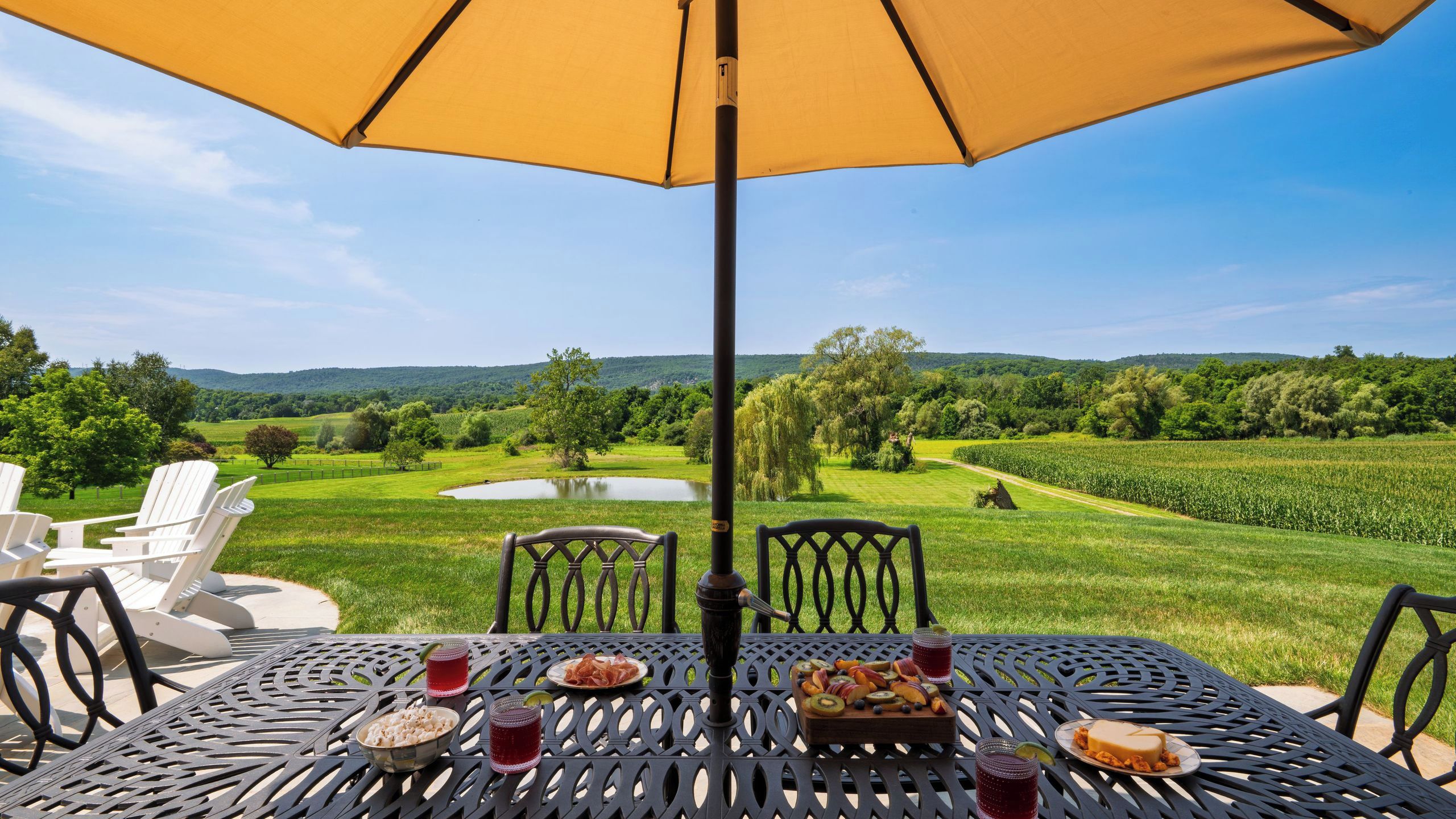 An outdoor dining area with a table, chairs, and an umbrella.
