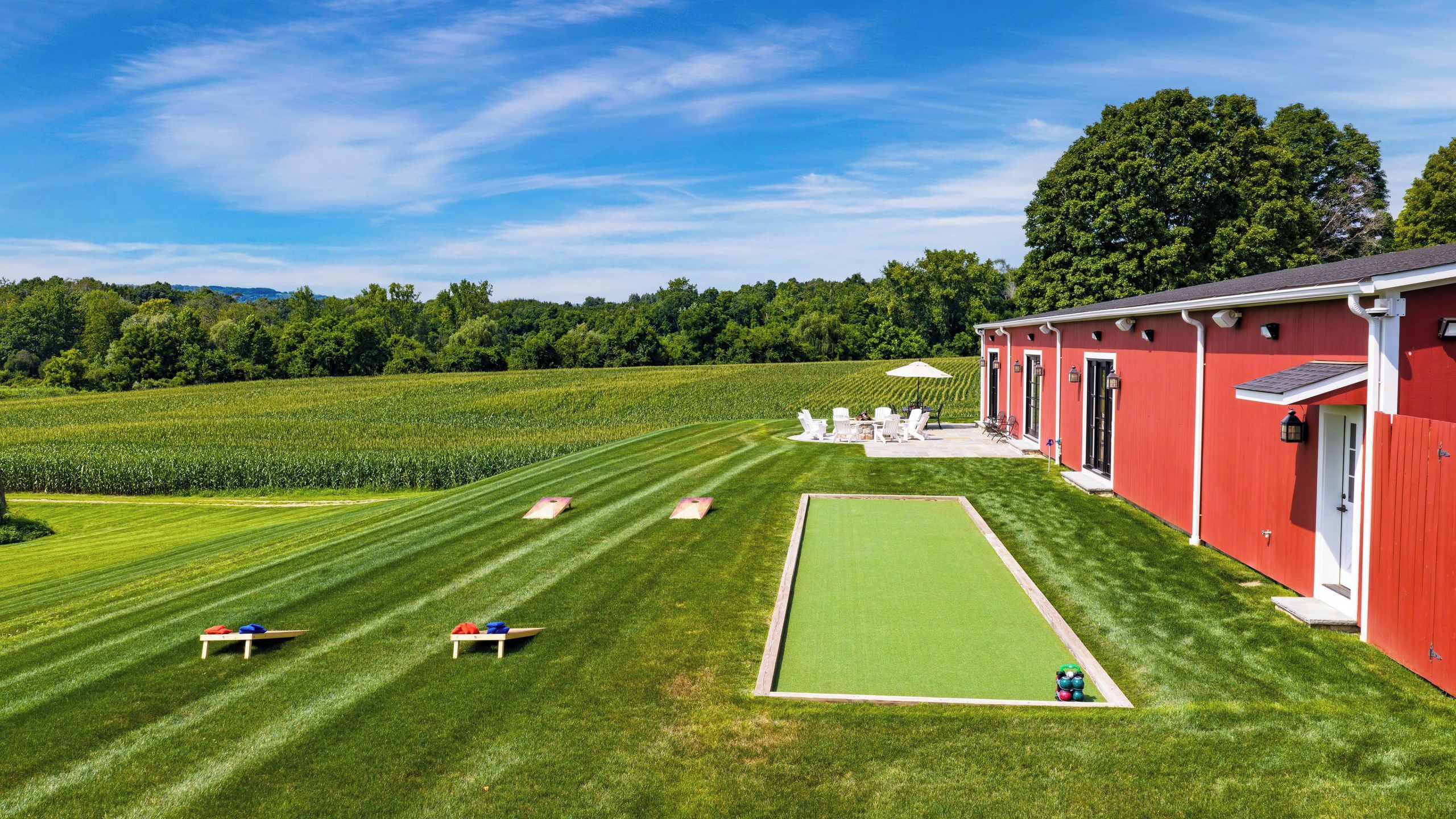 A red building with a lawn and croquet court.