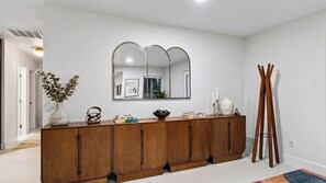 Un intérieur moderne avec une console en bois, un grand miroir et un grand présentoir en bois.