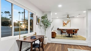 Un espace repas moderne avec une table en bois, des chaises et un ventilateur de plafond.