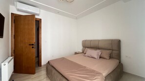 Ein Schlafzimmer mit einem Bett, einer Holztür und einem weißen Heizkörper.
