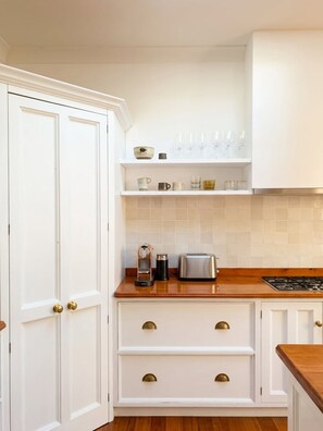 A kitchen with white cabinetry, a wooden countertop, and a range hood. - Avalon home flat 5 minute stroll to village (Avalon Beach)