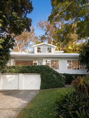 A two-story house with a covered porch, a garage, and a well-maintained lawn. - Avalon home flat 5 minute stroll to village (Avalon Beach)