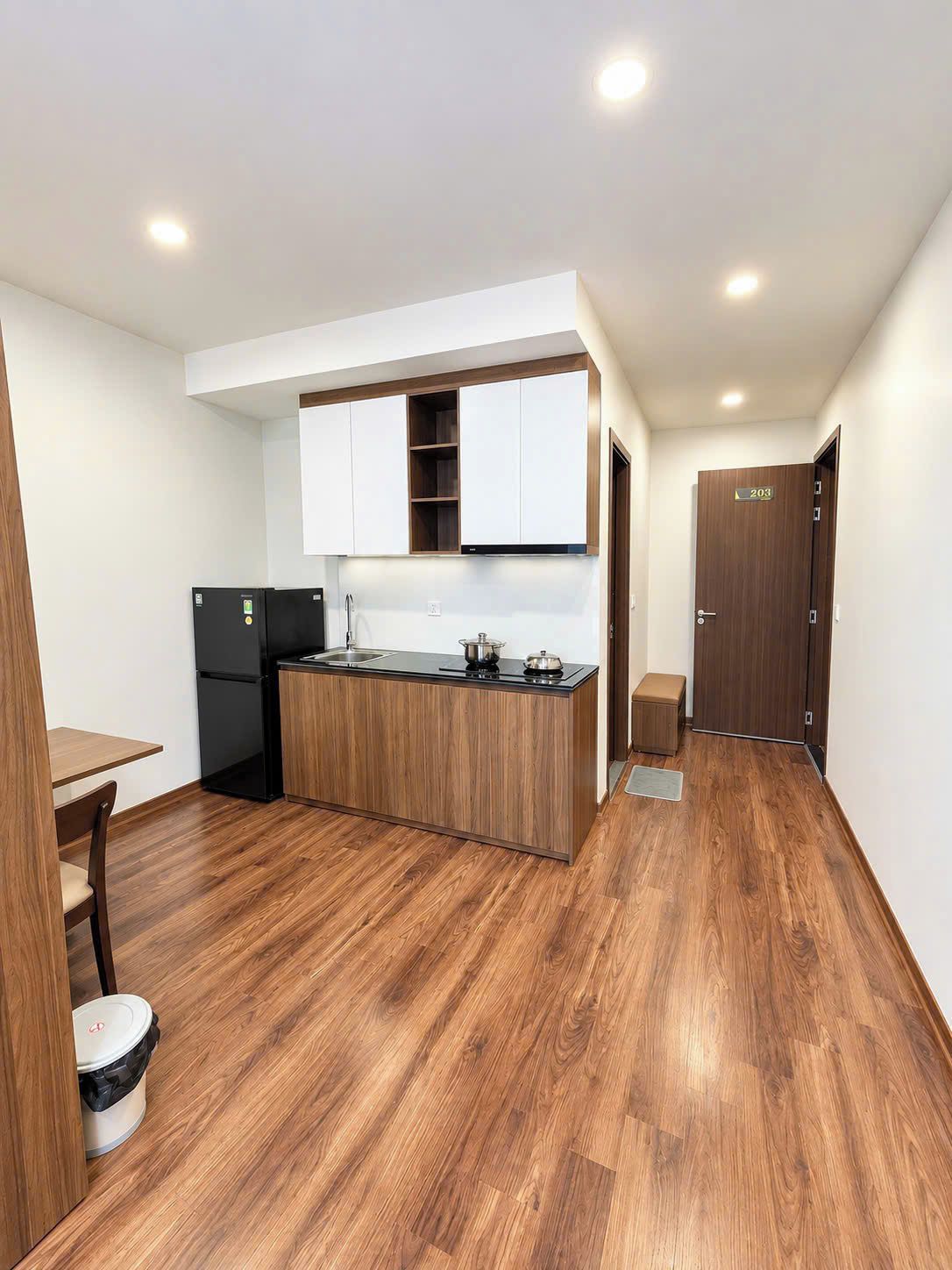 A compact kitchen with a wooden countertop, a built-in oven, and a refrigerator.
