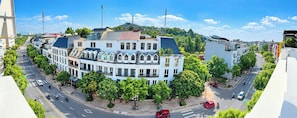A multi-story building with a curved facade, surrounded by trees and a clear sky. - Nam Hai Hotel & Apartment (Vĩnh Phúc)