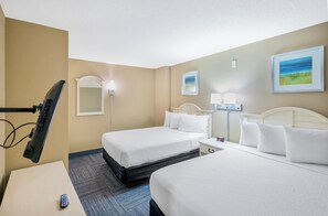 A hotel room with two beds, a desk, a TV, and a clock. - Stunning View Amazing Oceanfront on the 12th Floor (North Myrtle Beach)