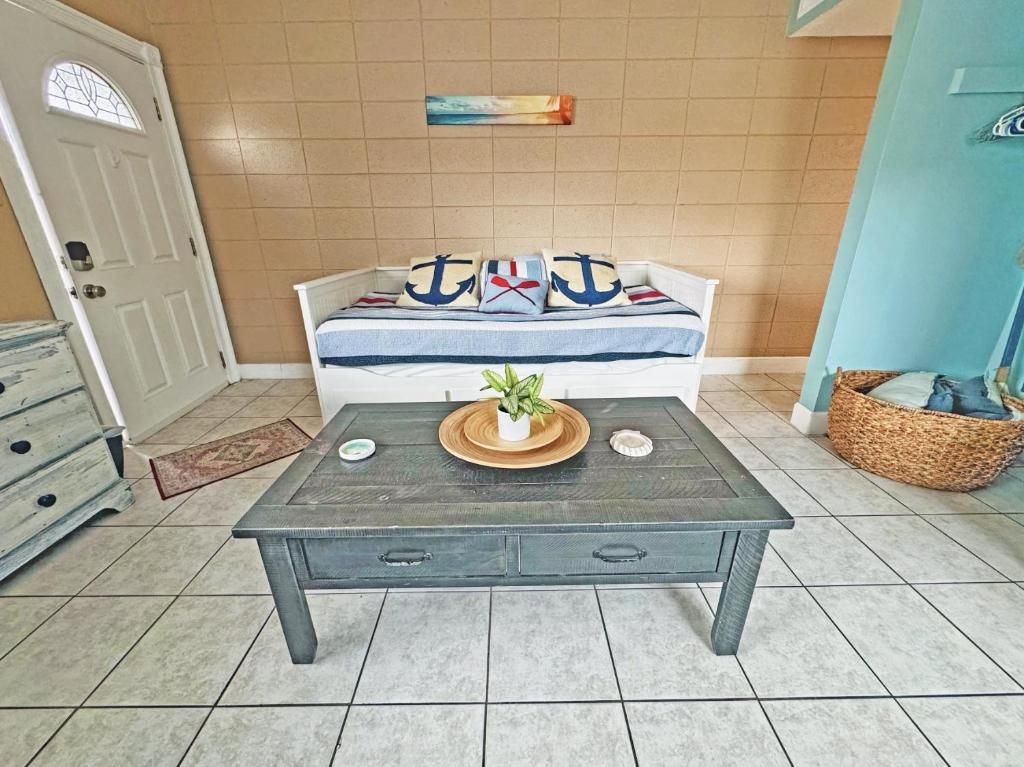 A room with a sofa against a wall, a coffee table in the center, and a door to the left.