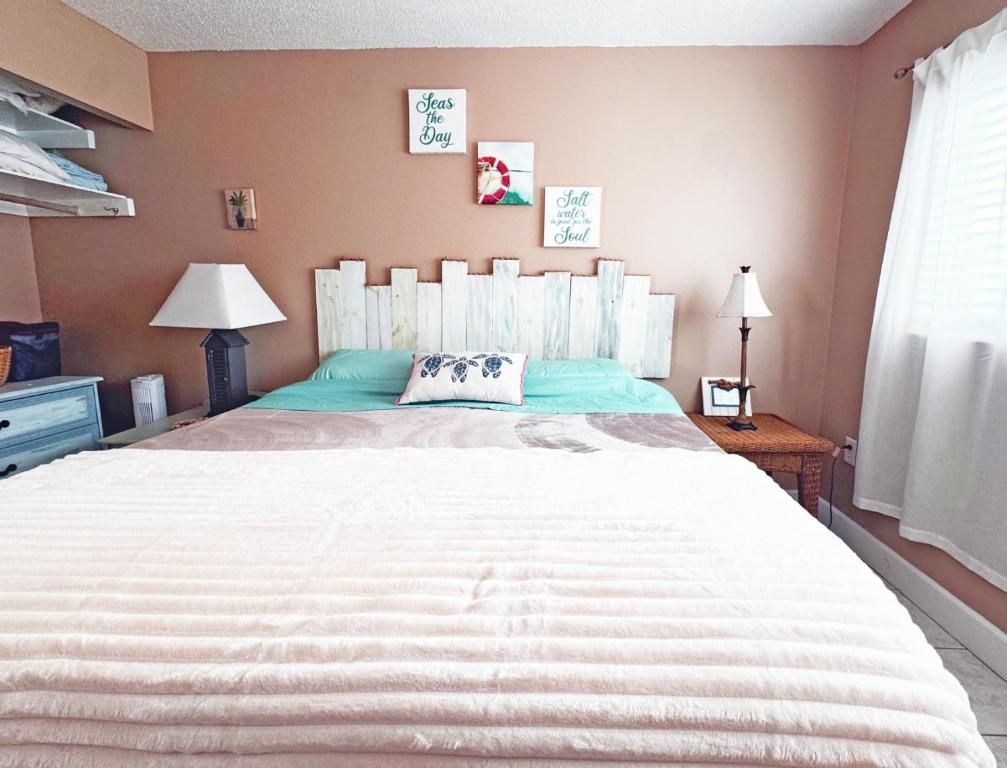 A bedroom with a bed, bedside tables, a lamp, and wall decorations.
