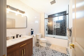 A modern bathroom with a marble vanity, a glass shower enclosure, and patterned floor tiles. - 82_Elegant 3BR Boston Home • 2 Baths + Parking • Near Red Line (Boston)