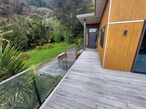 A modern building with a wooden exterior and a glass balcony overlooking a lush garden. - Willow Bay, Mahua Sound. Easy road & Beach access, tidal Beach launching/mooring (Mahau Sound)