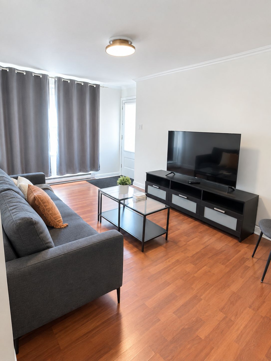 A modern living room with a sofa, a coffee table, a TV, and a cabinet.