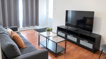 A modern living room with a sofa, a coffee table, a TV, and a cabinet.