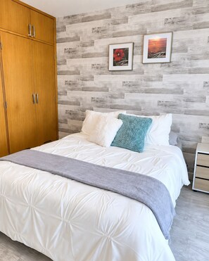 A bedroom with a bed, a wardrobe, and two framed pictures on the wall. - Hermoso Apt, Vista al Mar, Playa el Angel+Piscina (Pampatar)