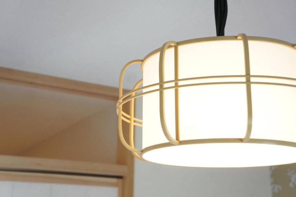 A hanging light fixture with a grid-like structure and a white shade.