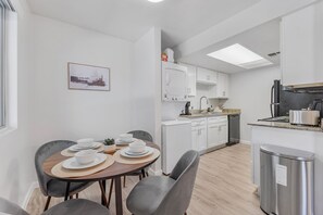 A modern kitchen with white cabinets, a built-in oven, and a stainless steel range hood. - Comfortable Mesa Retreat, 2 Queen Beds, & Pool (Mesa)