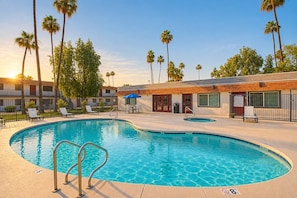 A swimming pool with lounge chairs and a building with a wooden facade. - Comfortable Mesa Retreat, 2 Queen Beds, & Pool (Mesa)