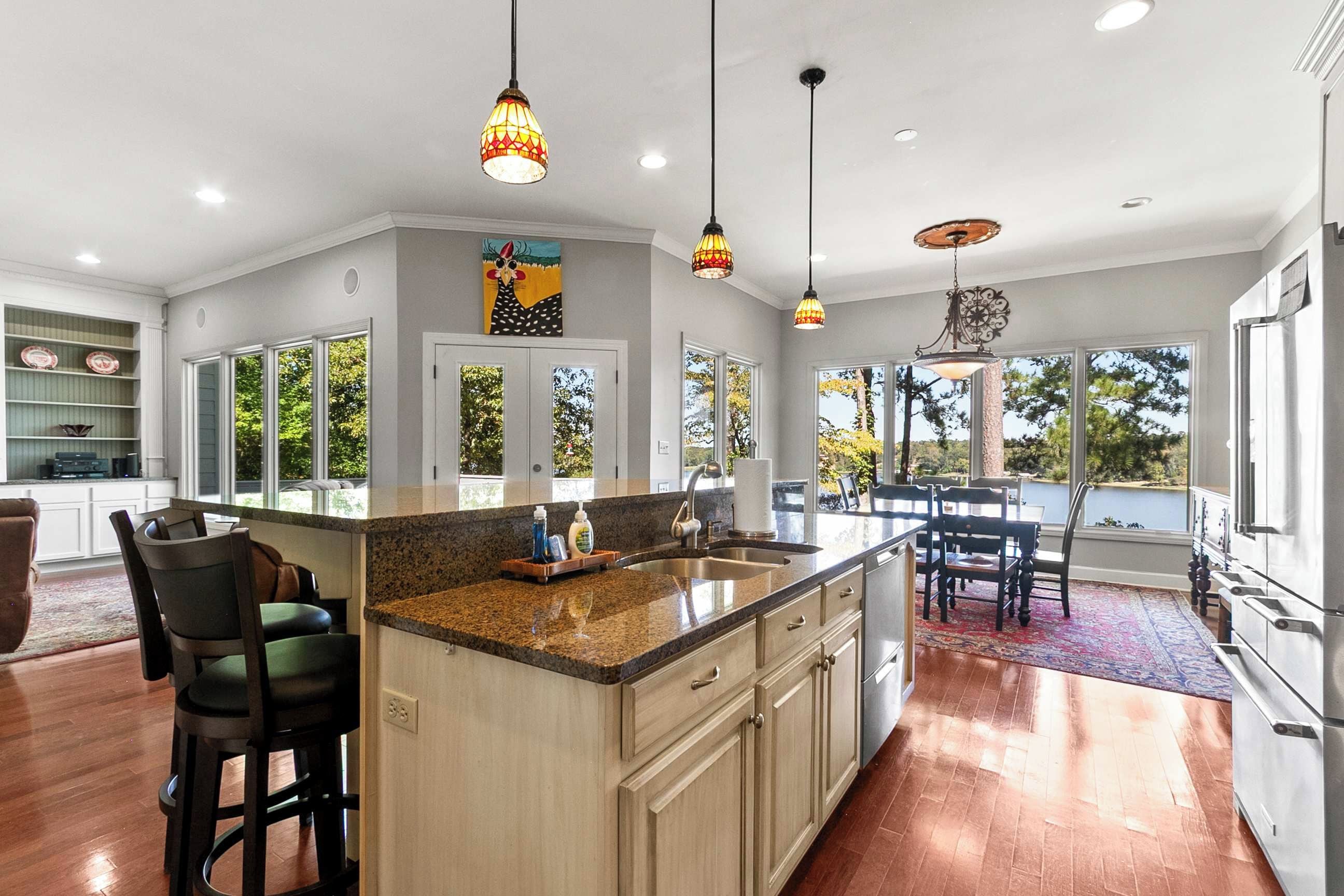 Una cocina amplia con una isla grande, iluminación colgante y vistas al exterior.