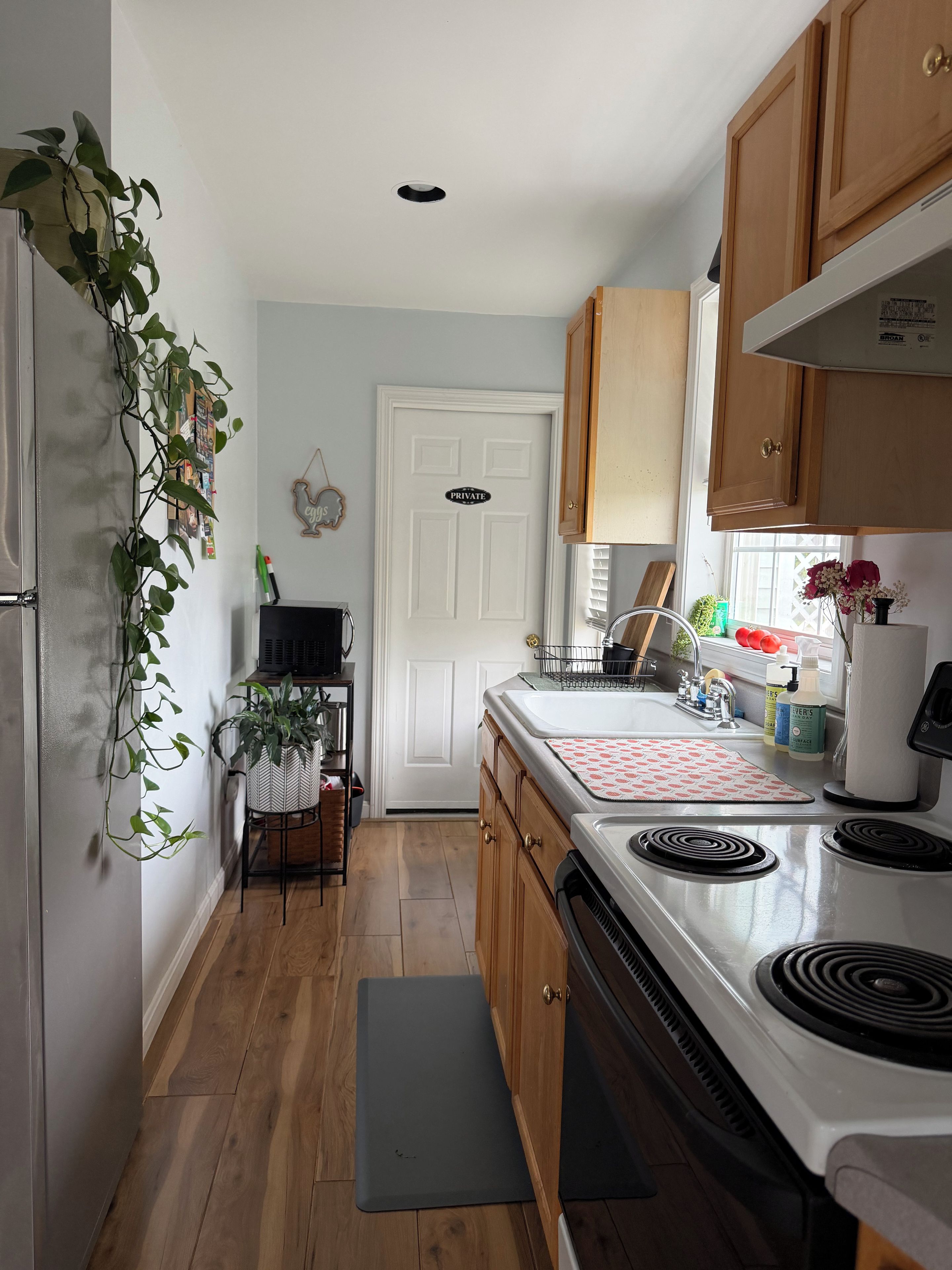 A kitchen with wooden cabinets, a white refrigerator, a stove, and a sink.