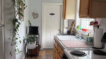 A kitchen with wooden cabinets, a white refrigerator, a stove, and a sink.