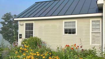 A single-story house with a dark metal roof and light siding.