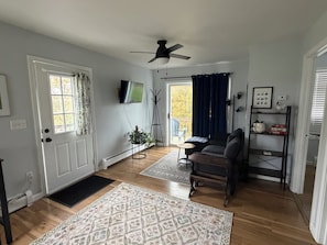 A living room with a sofa, a coffee table, a television, and a ceiling fan. - Peaceful Country Setting in Essex Junction perfect for a solo or couples retreat (Essex Junction)