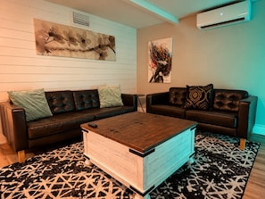 A living room with two leather sofas, a wooden coffee table, and patterned rugs. - Enjoyable, tropical 3-bedroom house w/ pool and leisure areas in sunny Tampa Bay (Tampa)