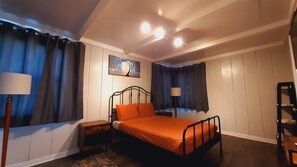 A bedroom with a bed, nightstands, a lamp, and a painting on the wall. - SHERWOOD ARMS MOTEL_CABIN #4 (Running Springs)