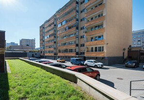 Ein mehrgeschossiges Wohngebäude mit Parkplatz davor.