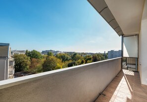 A balcony with a view of a cityscape and trees. - Ochota Standard Apartment (Warszawa)