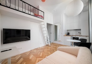 Apartamento moderno com quarto no mezanino, cozinha e sala de jantar.