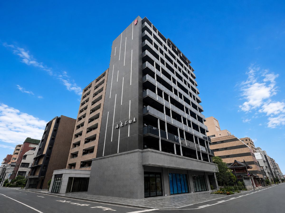 A multi-story building with a modern architectural design, featuring a prominent entrance with a blue door and a sign above it.