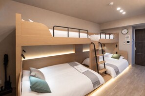 A bunk bed room with a wooden headboard, a ladder, and a bedside table with a lamp. - Ocean Dotonbori (Chuo-ku)