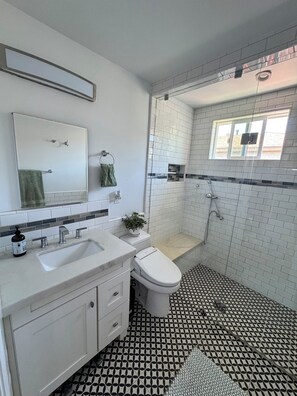 A bathroom with a white sink, a toilet, and a shower. - Charming bedroom in private home (Hawthorne)