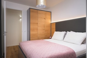 Une chambre à coucher avec un lit, une armoire et un luminaire au plafond.