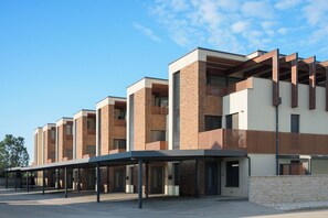 Un bâtiment moderne à étages, doté de grandes fenêtres et d’un espace d’entrée abrité.
