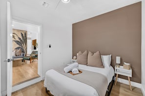 Ein Hotelzimmer mit Bett, Nachttisch und Blick auf den angrenzenden Wohnbereich.